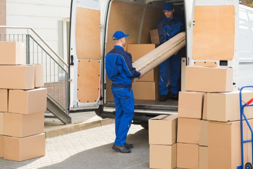 Man with van loading furniture in Kingston Vale on a residential street